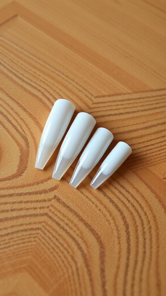 Coffin-shaped white chrome nails arranged on a wooden surface.