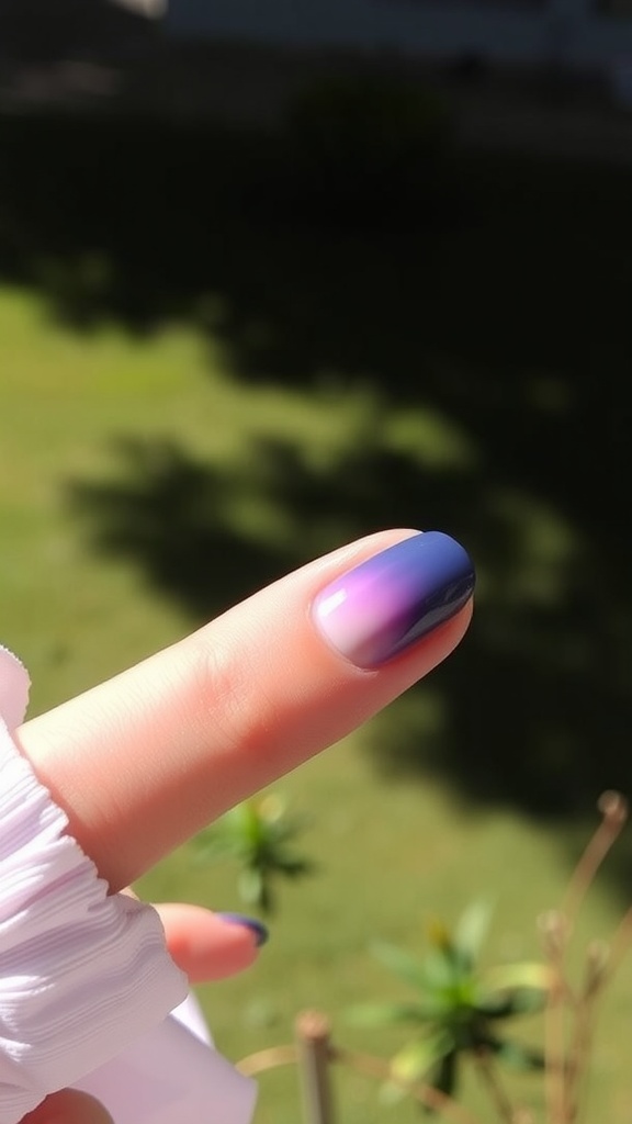 A close-up of a finger with dark blue and lilac gradient nails against a green background.