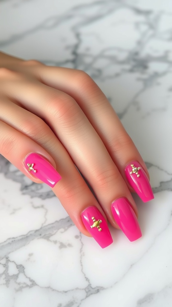 Close-up of hot pink nails with gold accents on a marble surface.